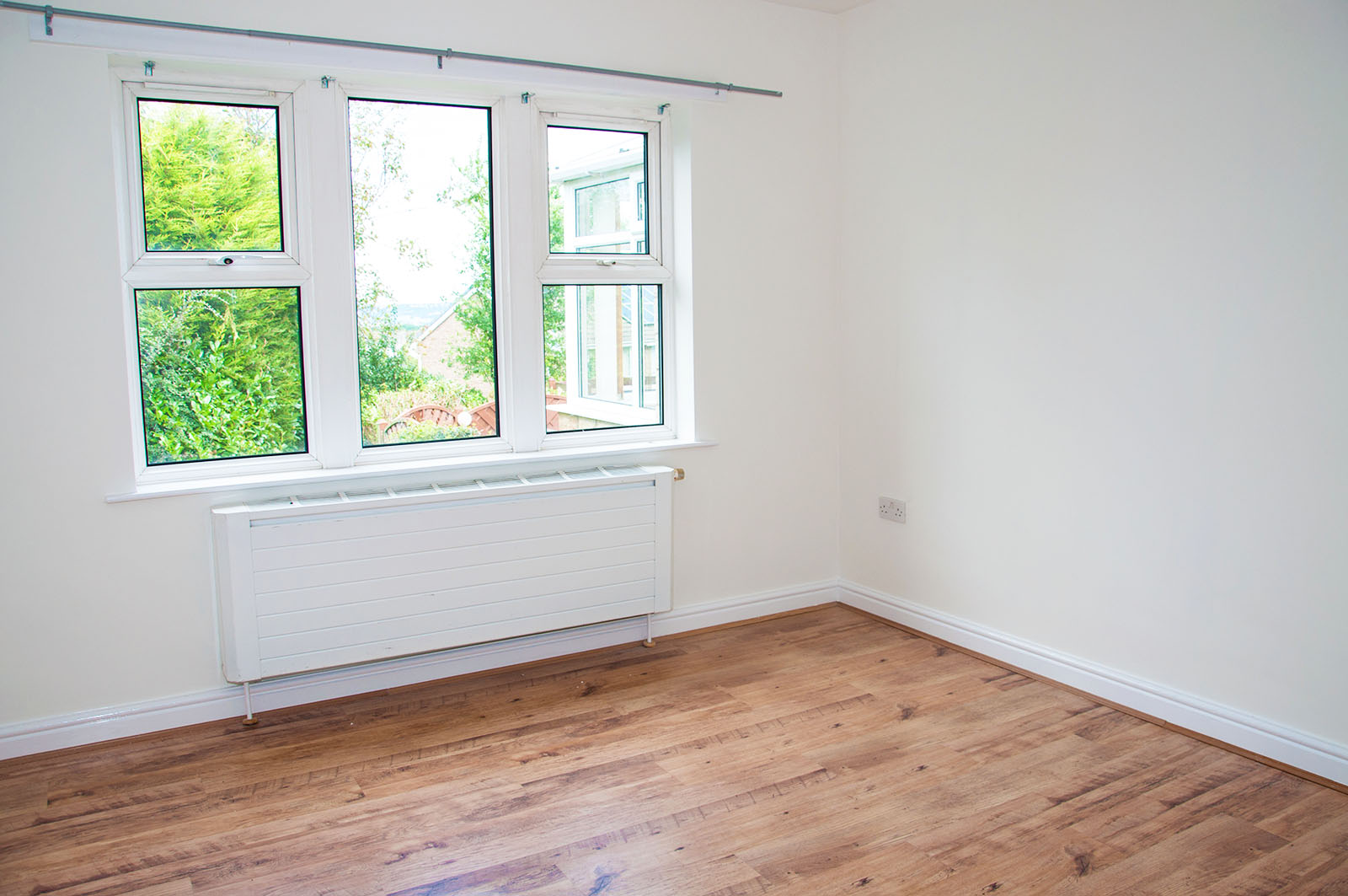 Living room with wooden floor and 3 windows