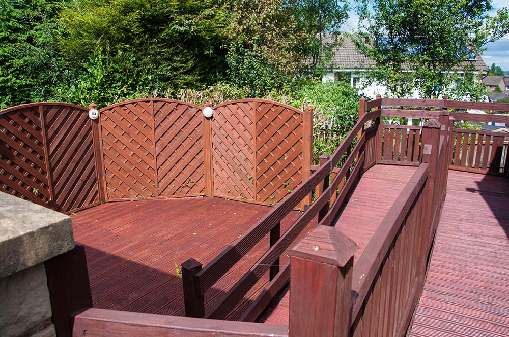 Outdoor wooden deck with a ramp leading down into the patio area