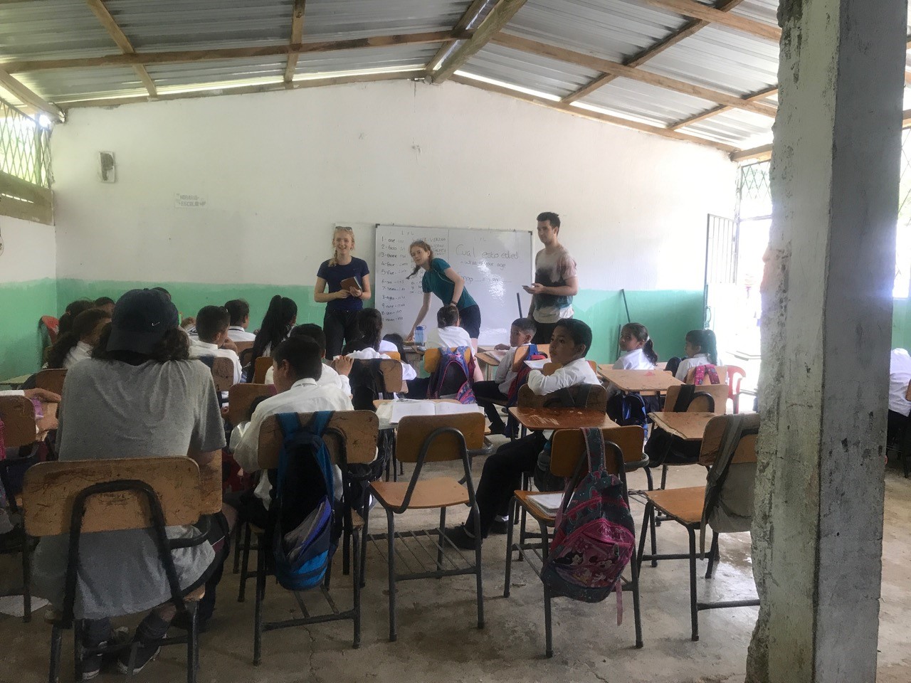 A classroom full of children and teachers at the front